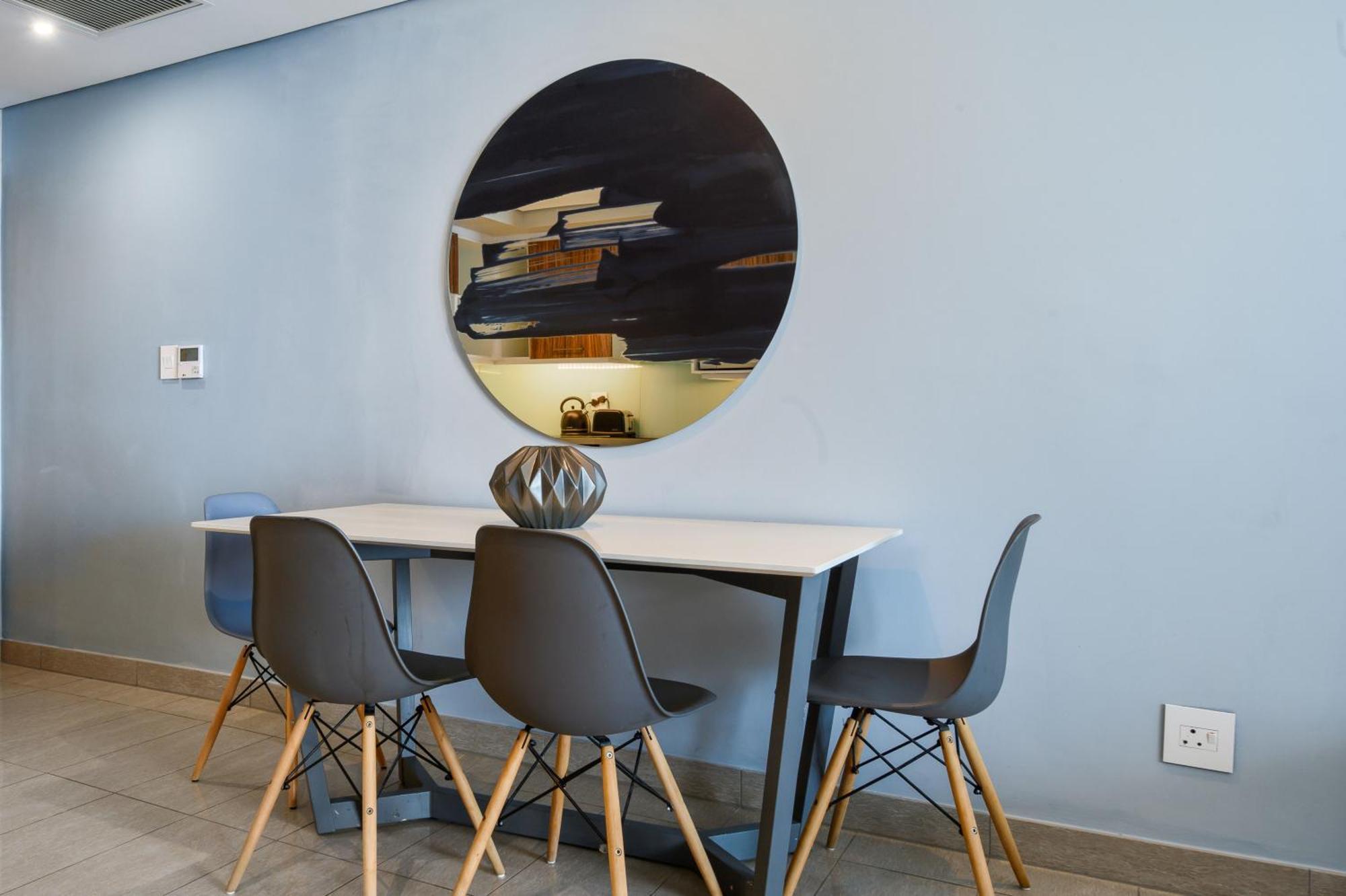 The Capital Pearls Hotel Durban Bagian luar foto A dining room with a table and chairs